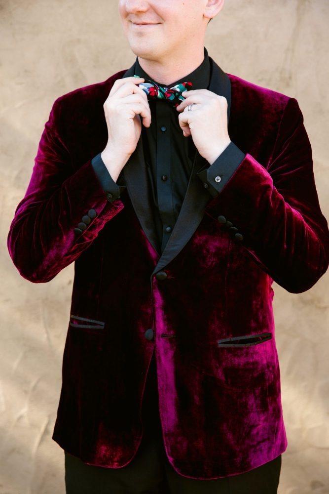 Red velvet suit with black button down and colorful bow tie