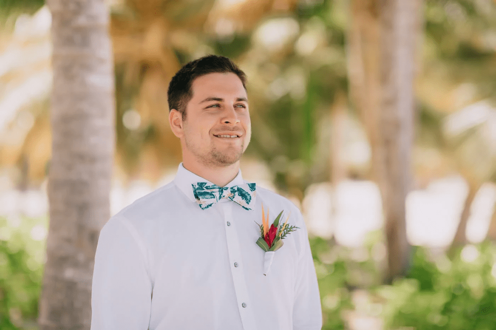 Groom in a white button down and tropical bow tie