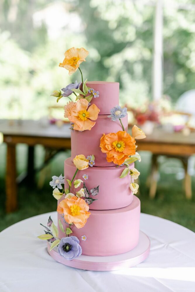 Pink wedding cake with colorful flowers