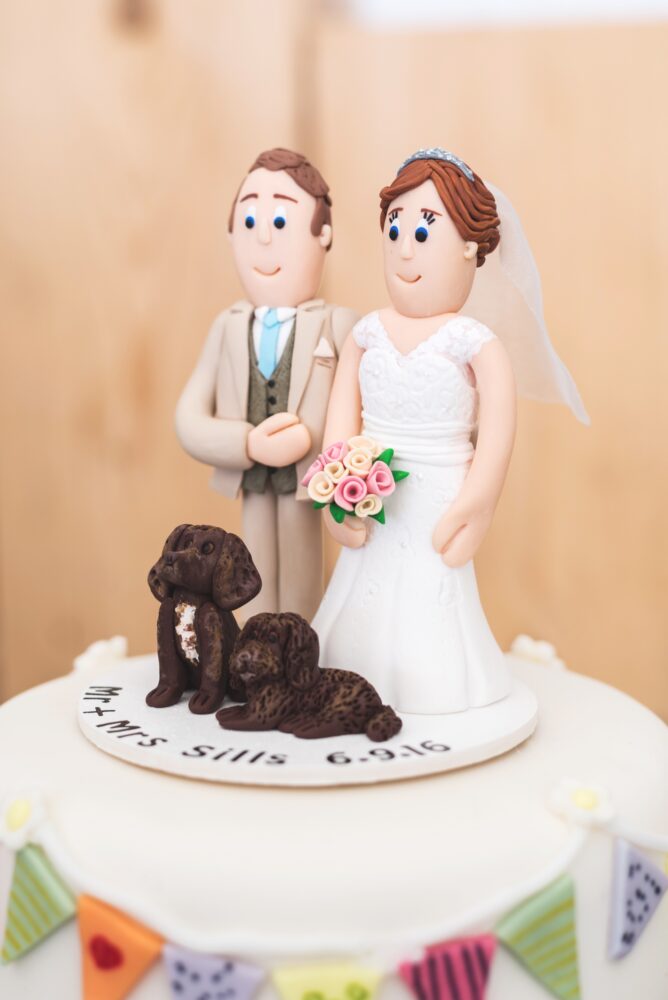 Wedding cake topper with bride and groom and two dogs