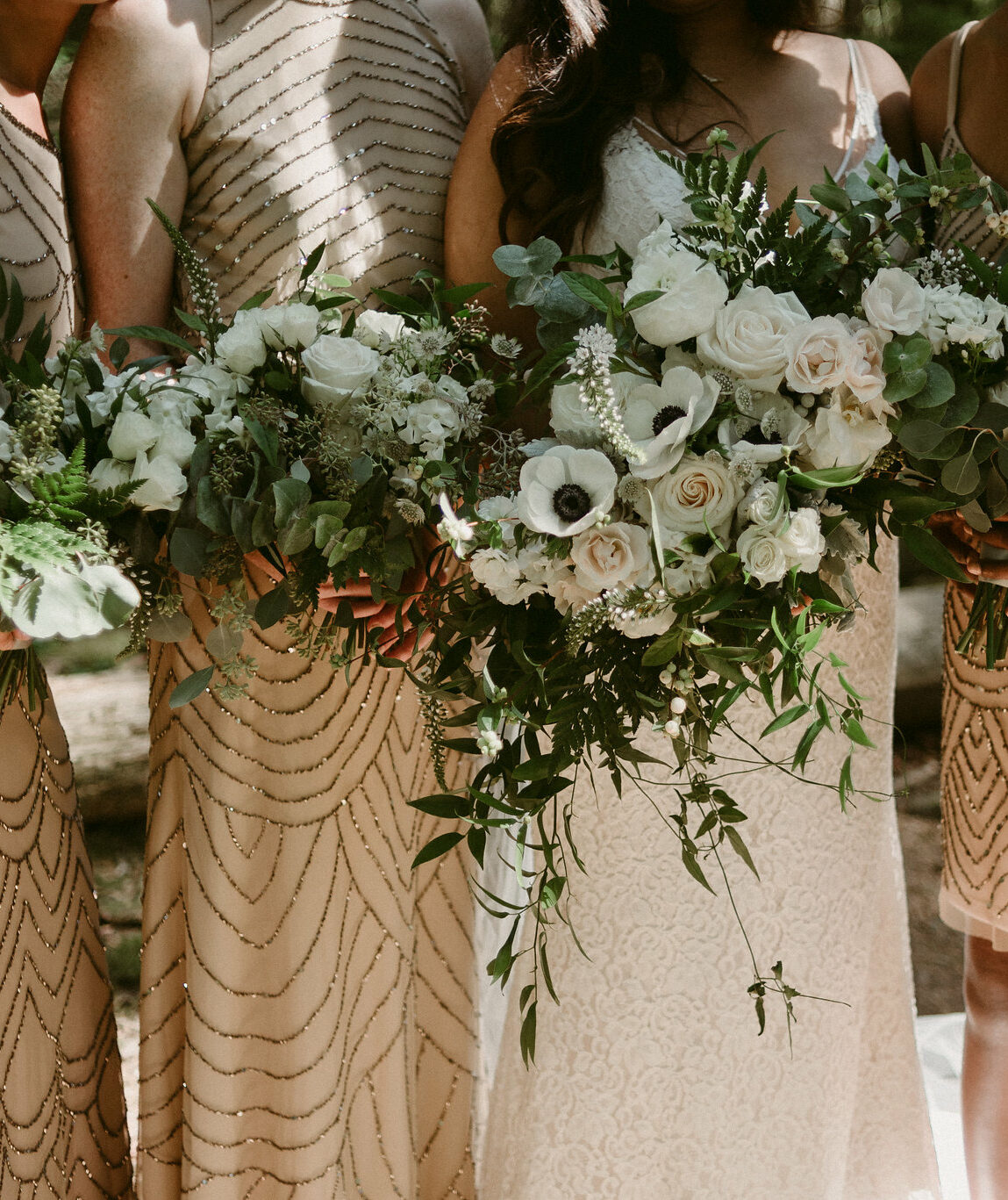 Bride and bridesmaids holding bouquets of flowers at wedding