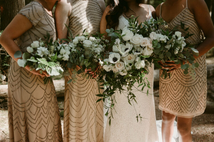 Bride and bridesmaids holding bouquets of flowers at wedding