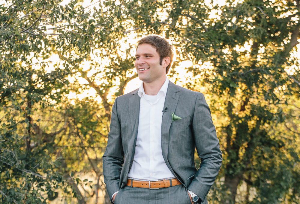 Groom wearing a white button-down and grey jacket