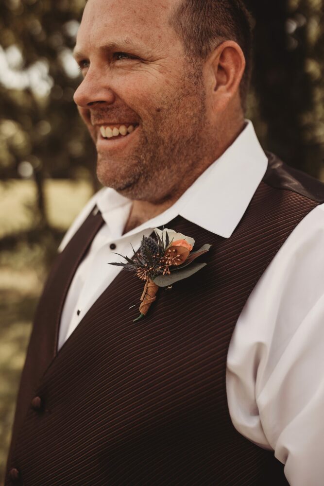 Close-up of a groom in a vest and jeans