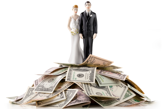 Bride and groom figurines on pile of money