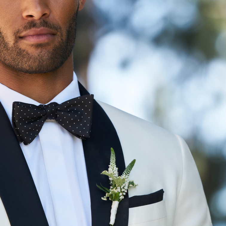 Groom in black and white suit wearing bowtie