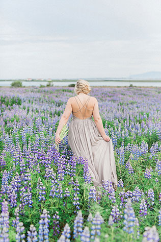 Lovely bohemian bridal portraits amongst the gorgeous purple lupine flowers in Iceland by Danielle Giroux