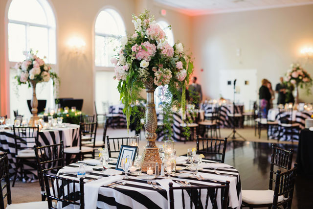 A chic black and white garden wedding in Raleigh featuring a stylish striped motif and a flower wall by Ginny Corbett Photography
