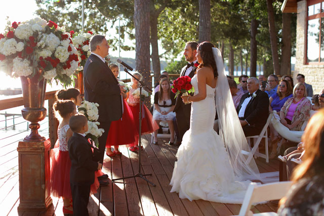 An intimate black and white striped wedding at Lake Tyler Petroleum Club with pops of vibrant red by Photography by Gema